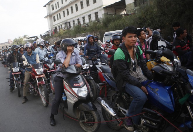 FILE - In this Sept. 28, 2015, file photo, Nepalese motorists wait for their turn to fill fuel on their motorbikes at a fuel pump run by the Nepalese army in Kathmandu, Nepal. Long lines of vehicles snaked around gasoline stations in Kathmandu amid fuel restrictions imposed by the government. The shortages come after Indian trucks carrying goods stopped at the border. Nepal obtains most of its fuel and other vital supplies from India. Many Nepalis believe that India has been retaliating against their government since Sept. 20, 2015, when it approved a new constitution seen by New Delhi as discriminatory to an ethnic Indian community - the Madhesi - living in Nepal's border districts. (AP Photo/Niranjan Shrestha, File)