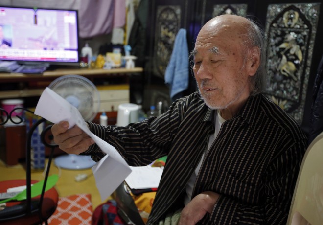 In this Oct. 15, 2015 photo, South Korean Kim Wu-jong, 87, who will travel to North Korea to meet his younger sister, looks at a document from the Red Cross during the interview at his home in Seoul, South Korea. Kim and about 640 other South Koreans will meet their North Korean relatives at the authoritarian countrys scenic Diamond Mountain resort in a reunion program that begins Tuesday, Oct. 20. Tens of thousands of people on both sides of the Demilitarized Zone desperately seek such reunions, but the two countries have pulled off relatively few of them. (AP Photo/Lee Jin-man)
