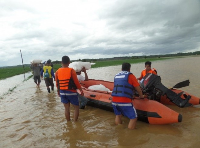 This photo provided by the Philippine Air Force, Philippine Air Force rescue team use rubber boats to distribute relief goods in Isabela province, northern Philippines on Sunday Oct. 18, 2015. Slow-moving Typhoon Koppu weakened after blowing ashore with fierce winds in the northeastern Philippines on Sunday, leaving at least two people dead, displacing 16,000 villagers and knocking out power in entire provinces, officials said.(Philippine Air Force via AP)