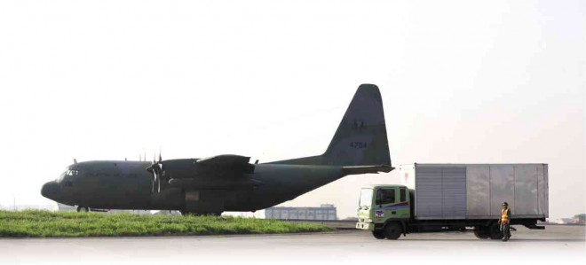 A TRUCK used for delivering relief goods passes by a C-130 plane leaving Villamor Air Base to bring relief goods to Aurora province. LYN RILLON
