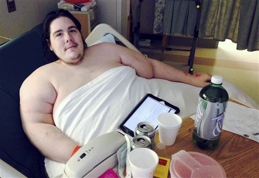 In this Monday, Oct. 12, 2015 photo, Steven Assanti, 33, rests in bed at Kent Hospital in Warwick, R.I. Assanti, of Cranston and who weighs nearly 800 pounds, said he was kicked out of another hospital for ordering pizza. Assanti said he is determined to slim down and hopes to eventually drop to 180 pounds. He said a surgeon read about him and offered to fly him to Texas to help him lose weight so he can have gastric bypass surgery. (AP Photo/Jennifer McDermott)