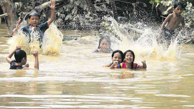 FROLICKING IN THE FLOODS  Kids will be kids, no matter the dangers posed by muddy floodwaters brought about by Tropical Storm “Lando” along Maharlika Highway in Cabanatuan City. Nueva Ecija towns and cities were among the worst-hit by rising floodwaters that poured down from surrounding mountains in the wake of the typhoon. GRIG C. MONTEGRANDE