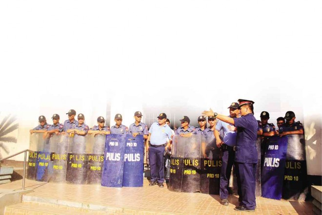 A PHALANX of policemen stands guard outside the Iligan City Hall as the city’s mayor and vice mayor fight over the mayor’s seat.  RICHEL UMEL 