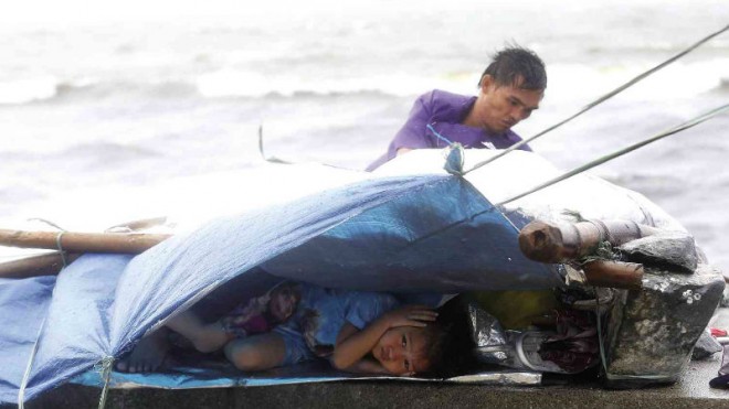 COLD AND HOMELESS Using tarpaulin and ropes, a man tries to provide shelter from the storm for his family on the seawall along Roxas Boulevard in Manila on Sunday as Typhoon “Lando” slams into Aurora and Isabela provinces, bringing heavy rain and powerful winds to much of Luzon. Weathermen said the slow-moving storm could stay over northern Luzon till Wednesday. MARIANNE BERMUDEZ