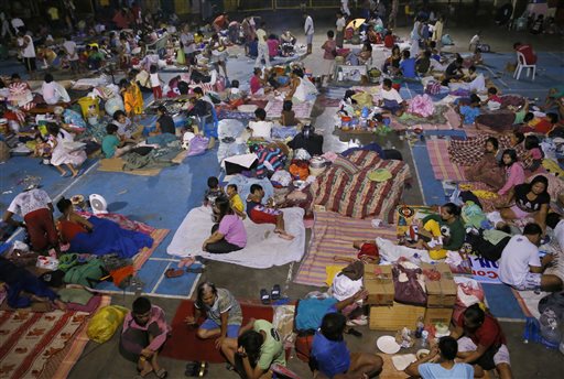 Typhoon evacuees are housed at a school gymnasium after fleeing their homes due to flooding brought about by Typhoon Koppu in Cabanatuan city in northern Philippines Monday, Oct. 19, 2015. The slow-moving typhoon  blew ashore with fierce wind in the northeastern Philippines early Sunday, toppling trees and knocking out power and communications and forcing the evacuation of thousands of villagers. AP PHOTO