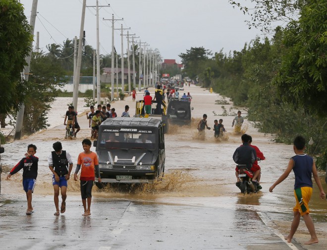 Residents wade through raging floodwaters brought about by Typhoon Koppu at Zaragosa township, Nueva Ecija province, north of Manila, Philippines Monday, Oct. 19, 2015. Slow-moving Typhoon Koppu blew ashore with fierce wind in the northeastern Philippines early Sunday, toppling trees and knocking out power and communications and forcing the evacuation of thousands of villagers.(AP Photo/Bullit Marquez)