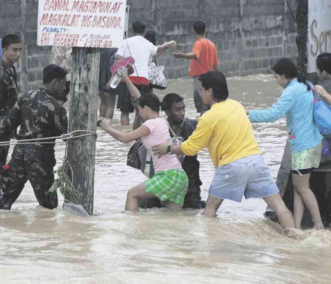 SOLDIERS guide people to safety as floodwaters rose in Rosales, Pangasinan, in 2009.  EDWIN BACASMAS