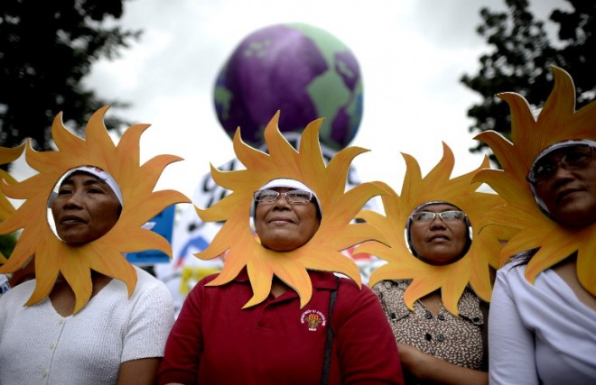 Protesters attend a climate change march on a highway in Manila on November 28, 2015. Thousands turned out for climate change marches in Manila and Brisbane on November 28, part of a weekend of action across the globe to demand results from next week's historic Paris summit.  AFP PHOTO / NOEL CELIS / AFP / NOEL CELIS