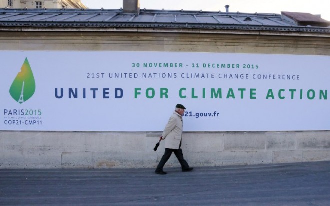 A man walks by a banner announcing the upcoming UN Climate Change Conference, the Cop 21 summit in Paris, on January 14, 2015.   AFP PHOTO /JACQUES DEMARTHON