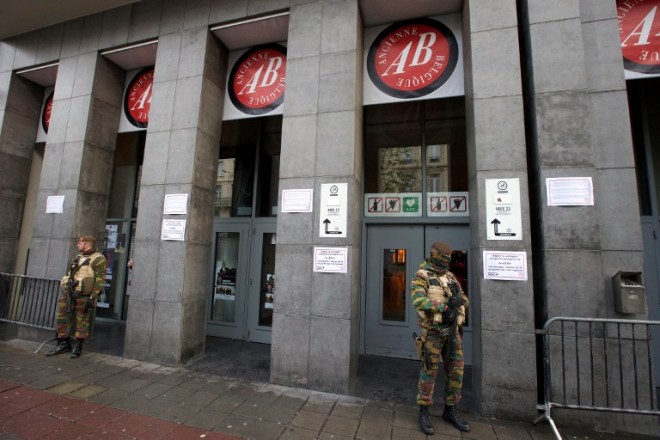 A picture taken on November 21, 2015 shows Belgian servicemen standing guard outside the closed Ancienne Belgique (AB) concert hall, in Brussels. Brussels was on terror lockdown on November 21 in fear of a Paris-style attack, with a gunman wanted over the deadly rampage in the French capital a week ago still on the run. The Belgian capital closed its metro system and shuttered shops and public buildings as a terror alert was raised to its highest level over reports of an "imminent threat" of a gun and bomb attack similar to the horror seen in Paris. AFP PHOTO / BELGA / NICOLAS MAETERLINCK    ***BELGIUM OUT*** / AFP / BELGA / NICOLAS MAETERLINCK