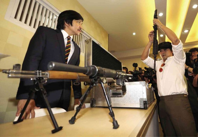 HIGH-CALIBER STAR  Actor Robin Padilla (right), accompanied by lawyer Rudolf Philip Jurado, hands over his four rifles to the Philippine National Police for “safekeeping” on Friday as he applies for new gun licenses.  RAFFY LERMA