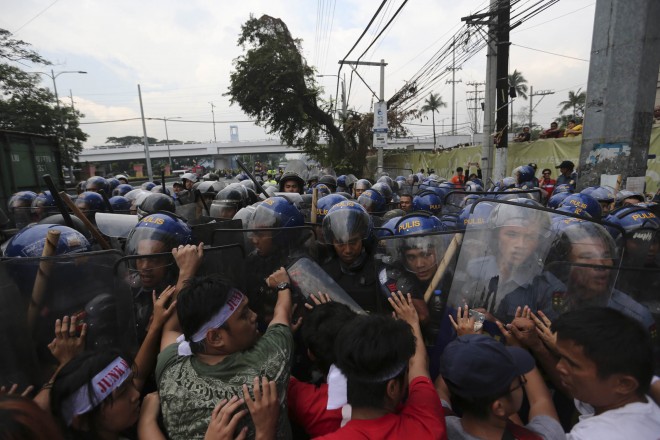 Protesters clash with anti-riot policemen along Gil Puyat Avenue as they attempt to approach PICC where the Asia Pacific Economic Cooperation Summit is being held on November 18, 2015. Leaders from APEC members are meeting to forge trade unity by promoting balanced, inclusive, sustainable, innovative and secure growth amongst member countries. PHOTO BY REM ZAMORA