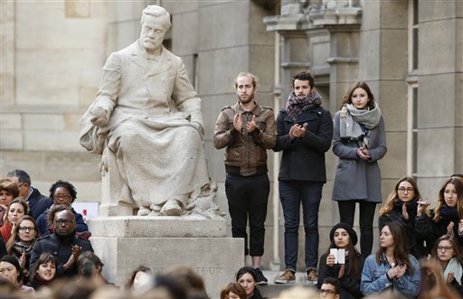 Students applaud after a minute of silence in the courtyard of the Sorbonne University in Paris, Monday, Nov. 16 2015. A minute of silence was observed throughout the country in memory of the victims of last Friday's attack. The statue shows late French chemist Louis Pasteur. (Guillaume Horcajuelo, Pool via AP)