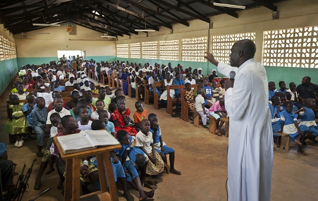 FILE - In this Sunday, Nov. 4, 2012 file photo, members of the congregation listen as Catechist Joseph Okuku, right, invites them to pray for President Barack Obama to be successful in his bid for re-election, during a service at the St. Richard Catholic Church in Kogelo, western Kenya. Pope Francis follows his predecessors next week Nov. 25-30, 2015 to visit Africa whose growing numbers of Catholics are seen as a bulwark for a church seeking to broaden its appeal amid secularism, competing Christian faiths and violent extremism, in a trip that will take him to Kenya, Uganda and the Central African Republic. (AP Photo/Ben Curtis, File)