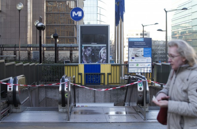 A woman walks past a closed subway station outside EU headquarters in Brussels on Monday, Nov. 23, 2015. The Belgian capital Brussels has entered its third day of lockdown, with schools and underground transport shut and more than 1,000 security personnel deployed across the country. (AP Photo/Virginia Mayo)