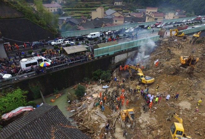 Rescuers search for victims following a landslide in Lishui in east China's Zhejiang province, Saturday, Nov. 14, 2015. Officials and state media say a torrent of mud and rocks unleashed by heavy rains has buried nearly 20 homes at a village in eastern China, killing at least four people and leaving 33 others missing.(Chinatopix via AP) CHINA OUT