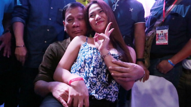 NO LAP DANCE HERE    A female supporter of Davao City Mayor Rodrigo Duterte, presidential candidate of PDP-Laban, sits on his lap at the MAD for Change event at McKinley West Open Field in Taguig City on Sunday night. GRIG C. MONTEGRANDE