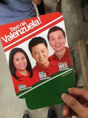 A cardboard fan bearing the image of three Valenzuela politicians were given away to cemetery goers on All Saints' Day. Photo by Jovic Yee, Philippine Daily Inquirer