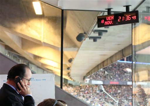 In this photo provided Friday, Nov. 13, 2015 by the French Presidential Palace, France's President Francois Hollande is pictured in the security control room at the Stade de France stadium in Saint Denis, north of Paris, during the international friendly soccer match between France and Germany. French President Francois Hollande vowed to attack Islamic State without mercy as the jihadist group admitted responsibility Saturday for orchestrating the deadliest attacks inflicted on France since World War II. (French Presidential Palace via AP)