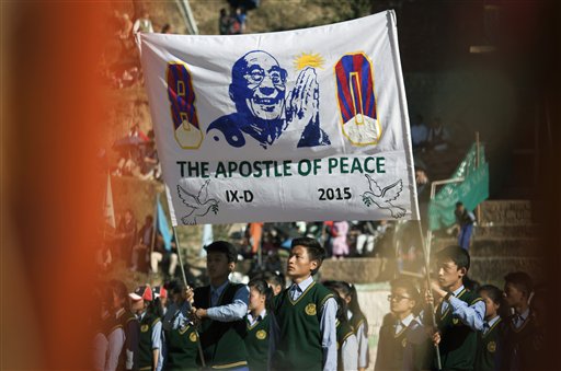 Exile Tibetan students carry a banner with a portrait of their spiritual leader the Dalai Lama during the Founding Anniversary celebrations of the Tibetan Children's Village School in Dharmsala, India, Friday, Oct. 23, 2015. The school, which started as an orphanage in 1960, houses and educates over 2000 refugee children. (AP Photo/Ashwini Bhatia)