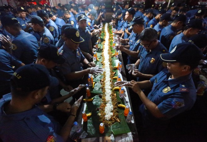 JUST DESSERTS About a thousand policemen from the provinces don disposable plastic gloves as they prepare to dig in and partake of the feast in a boodle fight set up at Quirino Grandstand in Rizal Park, their reward for the difficult task of securing the Apec summit this week. LYN RILLON 