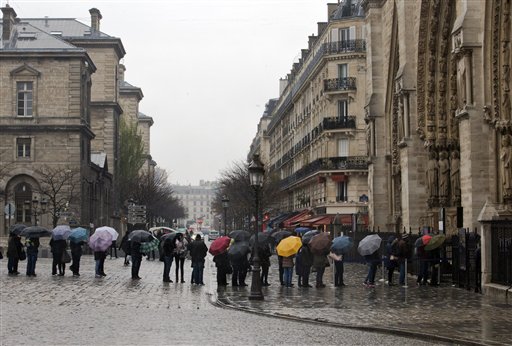 Tourists line up to enter Notre Dame cathedral, right, as security has been reinforced in the cathedral,  in Paris, Tuesday, Nov. 24, 2015. French authorities on Tuesday questioned a top suspect linked to attackers who terrorized Paris, while Belgium's capital remained locked down under threat of a possible similar attack.(AP Photo/Jacques Brinon)