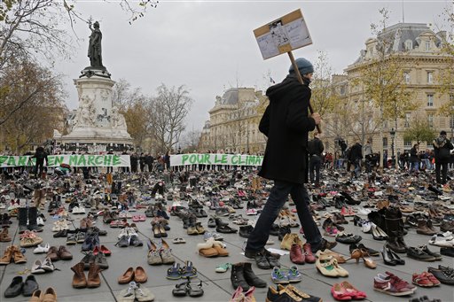 A man walks between shoes as hundreds of pairs of shoes are displayed at the place de la Republique, in Paris, as part of a symbolic and peaceful rally called by the NGO Avaaz "Paris sets off for climate", Sunday, Nov. 29, 2015.  More than 140 world leaders are gathering around Paris for high-stakes climate talks that start Monday, and activists are holding marches and protests around the world to urge them to reach a strong agreement to slow global warming. (AP Photo/Laurent Cipriani)