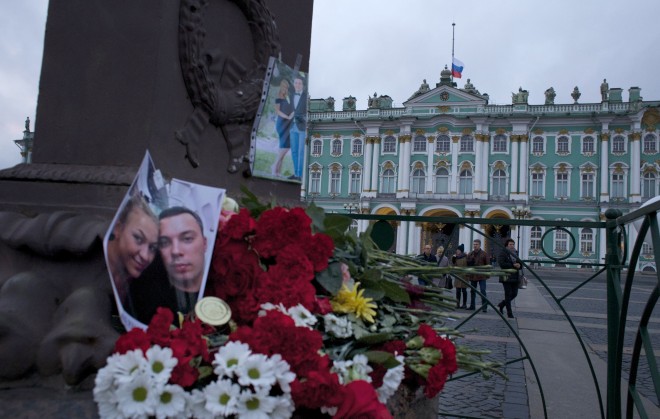 Pictures of the plane crash victims and flowers lie in memory to victims of a Metrojet plane crashed in Egypt as Russian national flag flies at half staff over the Winter Palace at Dvortsovaya (Palace) Square in St. Petersburg, Russia, on Monday, Nov. 2, 2015. In a massive outpouring of grief, thousands of people flocked to St. Petersburg's airport, laying flowers, soft toys and paper planes next to the pictures of the victims of the crash of a passenger jet in Egypt that killed all 224 on board in Russia's deadliest air crash to date. (AP Photo/Ivan Sekretarev)