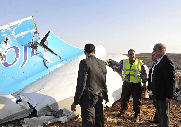 In this image released by the Prime Minister's office, Sherif Ismail, right, looks at the remains of a crashed passenger jet in Hassana Egypt, Friday, Oct. 31, 2015. A Russian aircraft carrying 224 people, including 17 children, crashed Saturday in a remote mountainous region in the Sinai Peninsula about 20 minutes after taking off from a Red Sea resort popular with Russian tourists, the Egyptian government said. There were no survivors.(Suliman el-Oteify, Egypt Prime Minister's Office via AP)