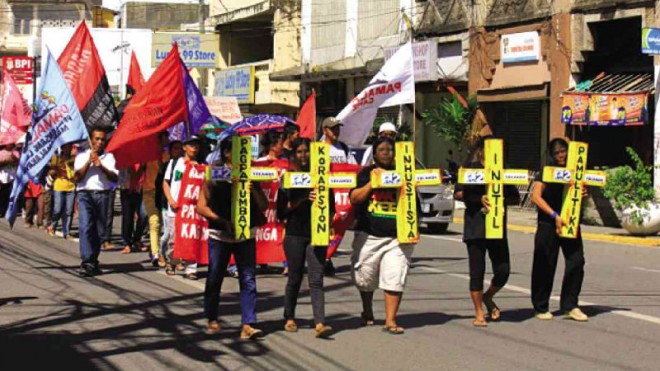 UNFAIR  Survivors of Supertyphoon “Yolanda” march in Roxas City, Capiz, to protest alleged irregularities in the distribution of the government’s emergency shelter assistance. CONTRIBUTED PHOTO