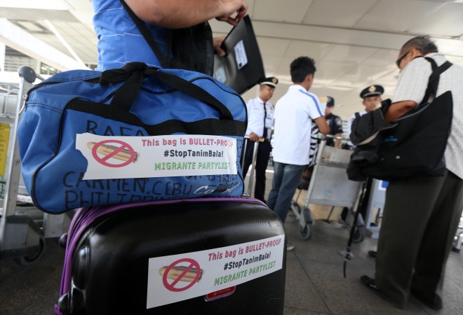 November 3, 2015 Stickers bearing Stop Tanim Bala warnings are handed out to passengers entering the NAIA Terminal 2, in Pasay City, by militant group Migrante to discourage anyone from planting bullets in their baggages. INQUIRER/ MARIANNE BERMUDEZ