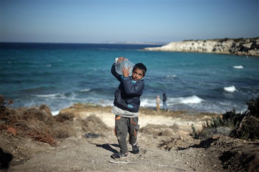 A boy carries a can of water near a beach from where migrants are traveling by dinghies to the Greek island of Chios from Turkish coast near Cesme, Izmir, Turkey, Wednesday, Nov. 4, 2015. More than 300,000 people have traveled on dinghies and boats from nearby Turkey to Greek islands this year, with dozens dying along the way.(AP Photo/Emre Tazegul)
