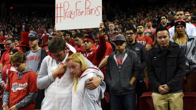 In this image made available by the Las Vegas News Bureau, UNLV fans observe a moment of silence for the victims of the terrorist attacks in Paris Friday, Nov. 13, 2015 before UNLV's basketball game against Cal Poly at the Thomas & Mack Center in Las Vegas. (Sam Morris/Las Vegas News Bureau via AP)