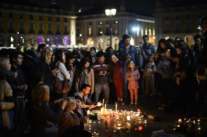 People light candles on Comercio square in Lisbon, on November 14, 2015 during a solidarity gathering for victims and families following a series of terror attacks in the French city of Paris and its surroundings that has left at least 120 people dead and some 200 wounded. A spate of co-ordinated attacks left 128 dead and 200 injured in Paris last night, a day after twin bombings in Beirut left 44 dead, and nearly two weeks after IS claimed it downed a Russian jet leaving Egypt, killing 224 on board. in Madrid on November 14, 2015.   AFP PHOTO / PATRICIA DE MELO MOREIRA