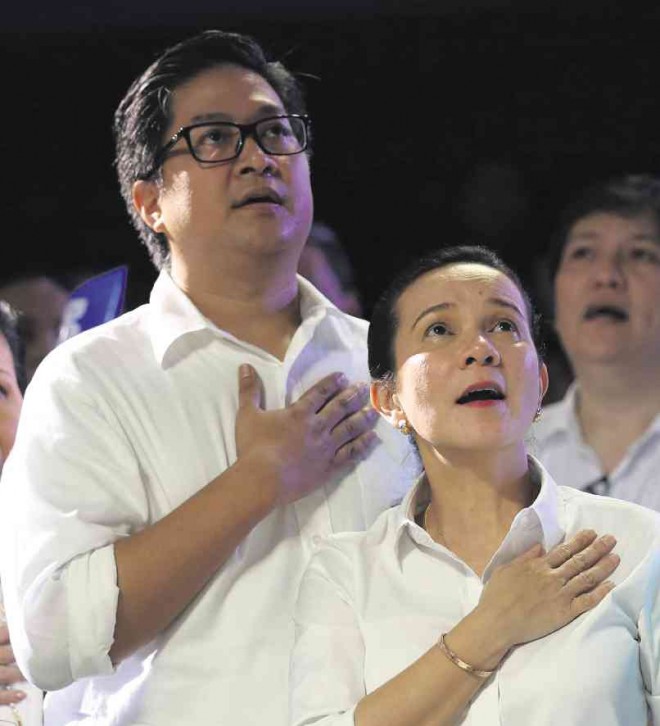 A QUESTION OF CITIZENSHIP      Sen. Grace Poe and her husband, an American citizen, sing the Philippine national anthem, “Lupang Hinirang.” Poe said her husband has already started the process of renouncing his American citizenship. LYN RILLON