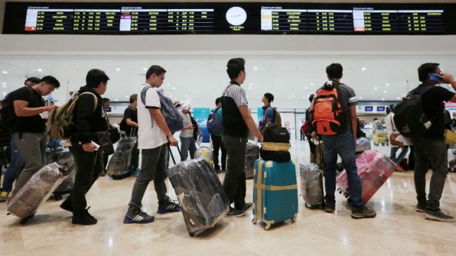 SEALED BAGGAGE Overseas Filipino workers (OFWs) with their baggage wait in line to check in at Naia Terminal 1. The OFWs have resorted to wrapping their luggage in plastic to guard against the “tanim-bala” (bullet-planting) scam. GRIG C. MONTEGRANDE