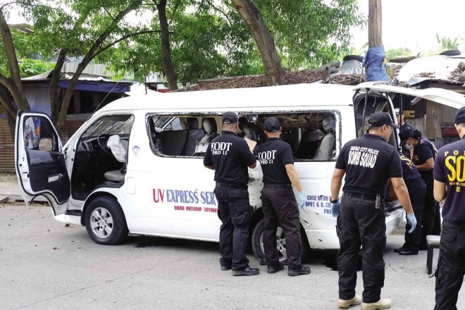 BOMB experts inspect a passenger van after a homemade bomb exploded inside it near a mall in Davao City, injuring its driver and conductor. KARLOS MANLUPIG / INQUIRER MINDANAO