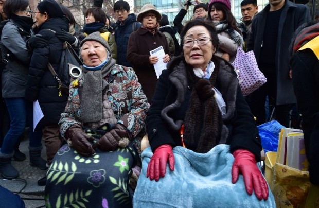 South Korean former "comfort women" Lee Yong-Soo (R) and Gil Won-Ok (C), who were forced into wartime sexual slavery for Japanese soldiers, sit during an anti-Japanese rally commemorating the death of nine former sex slaves this year in front of the Japanese embassy in Seoul on December 30, 2015. South Korean "comfort women" and supporters vowed to step up protests against a deal between Seoul and Tokyo on resolving a long-running row over the comfort women. AFP PHOTO / JUNG YEON-JE / AFP / JUNG YEON-JE