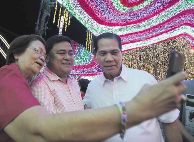  ‘ALL IS BRIGHT’ Alexander Cruz, center, poses for a selfie with visitors at his sparkling Cainta residence. AP