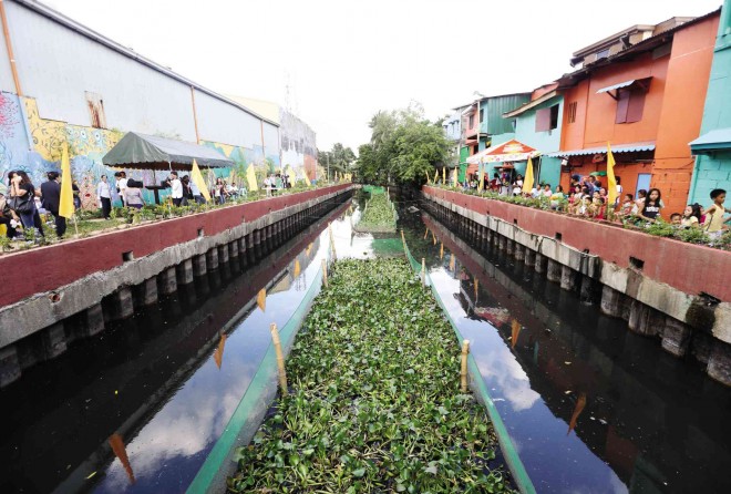 WALLS, WATER COME ALIVE Colorful murals along the banks form part of the P2-million rehabilitation project for Estero de Pandacan in Manila, one of the 47 tributaries of Pasig River.   The waterway itself (lower photo) is given a touch of green by patches of water hyacinth fixed in place by nets.
