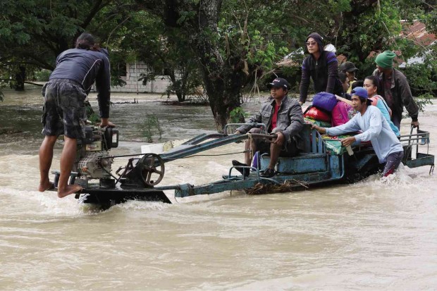 In La Paz, Tarlac province, the “kuliglig” (tractor) is reinvented as a ferry (right), as it transports commuters across the flooded plains. NIÑO JESUS ORBETA
