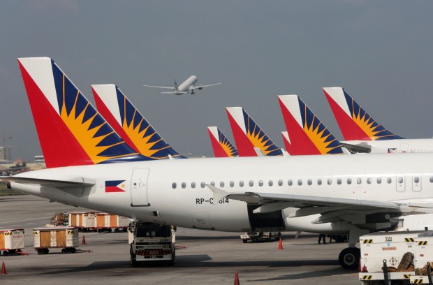 FLAG CARRIER / JUNE 29, 2015 A plane takes off at a distance while Philiippine Airlines fleet parked at the Ninoy Aquino International Airport (NAIA) terminal 2. INQUIRER PHOTO / GRIG C. MONTEGRANDE