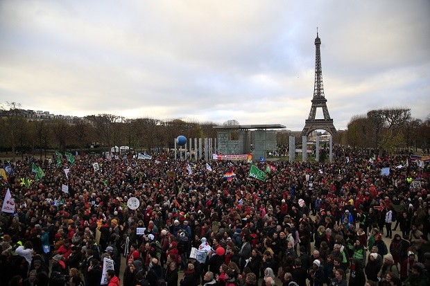 Activists gather near the Eiffel Tower, in Paris, Saturday, Dec.12, 2015 during the COP21, the United Nations Climate Change Conference. As organizers of the Paris climate talks presented what they hope is a final draft of the accord, protesters from environmental and human rights groups gather to call attention to populations threatened by rising seas and increasing droughts and floods. (AP Photo/Thibault Camus)