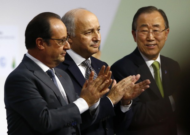 French President Francois Hollande, left, French foreign minister Laurent Fabius, center, and United Nations Secretary General Ban Ki-moon applaud at the COP21, the United Nations Climate Change Conference, in Le Bourget, north of Paris, Saturday, Dec.12, 2015. Fabius says a "final" draft of a global climate pact would be legally binding. (AP Photo/Francois Mori)