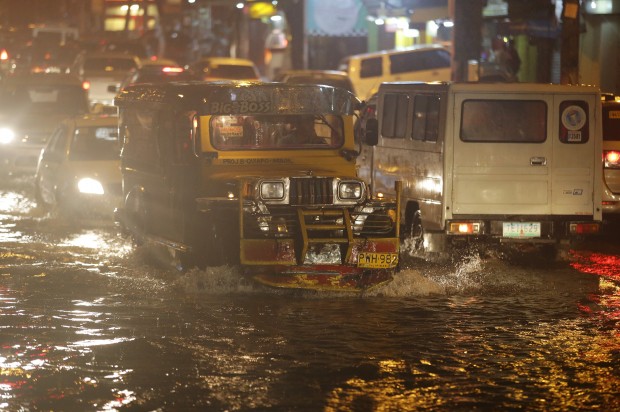 A passenger jeep drives through flooded streets caused by rains from Typhoon Melor in suburban Quezon city, north of Manila, Philippines on Tuesday, Dec. 15, 2015. Typhoon Melor weakened Tuesday as it crossed over the central Philippines, leaving one man dead and wide areas without power. (AP Photo/Aaron Favila)