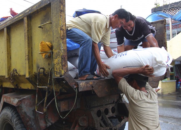 Workers unload sacks of rice intended for typhoon evacuees in Legazpi city, central Philippines as Typhoon Melor slammed into the eastern Philippines, Monday, Dec. 14, 2015. Hundreds of thousands of residents fled their homes as Typhoon Melor slammed into the eastern Philippines, where flood- and landslide-prone communities are bracing for destructive winds, heavy rains and coastal floods of up to 4 meters (13 feet), officials said Monday. (AP Photo/Roldano Amaranto)