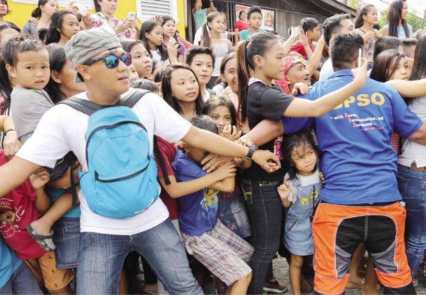 Village watchmen form a human barricade to prevent enthusiastic fans from rushing to their idols, actors Alden Richards and Maine Mendoza, as the pair made famous by portraying the characters “AlDub” in the noontime TV hit “Kalyeserye” segment of “Eat Bulaga” bring their antics to Cebu City. JUNJIE MENDOZA/CEBU DAILY NEWS