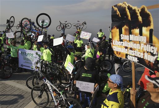 Filipinos raise their bicycles as they join a rally in Manila, Philippines on Sunday, Dec. 13, 2015 to criticize the agreement reached during the United Nations conference on climate change, Conference of Parties 21 (COP21) in Paris. Nearly 200 nations adopted the first global pact to fight climate change on Saturday, calling on the world to collectively cut and then eliminate greenhouse gas pollution but imposing no sanctions on countries that don’t. (AP Photo/Aaron Favila)