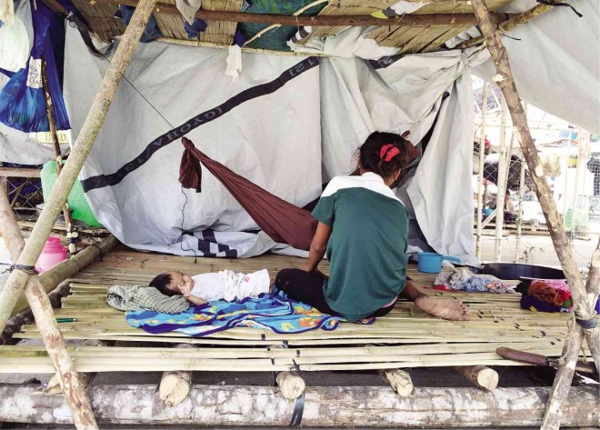 A WOMAN and her child are among almost 3,000 “lumad” who have been staying in makeshift tents in Tandag City in Surigao del Sur province for more than three months since they fled their communities after the killings.  NICO ALCONABA/  INQUIRER MINDANAO 