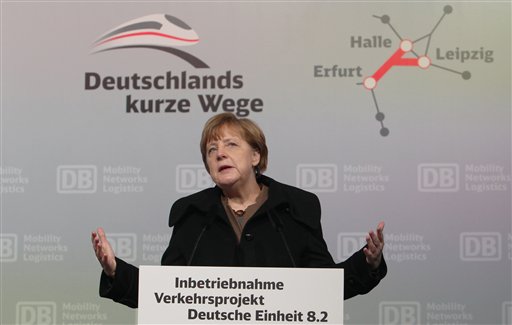 German Chancellor Angela Merkel delivers a speech during the opening ceremony of the new high-speed rail line between Erfurt and Halle/Leipzig at the central station in Leipzig, Germany, Wednesday, Dec. 9, 2015. Letters in the background read: "Germany's short ways". (Sebastian Willnow/dpa via AP)